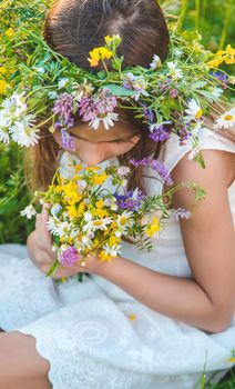 Child girl with wildflowers in summer. Selective focus. Nature.