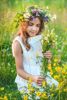 Child girl with wildflowers in summer. Selective focus. Nature.