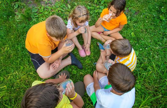 Children drink water outside together. Selective focus. Kids.