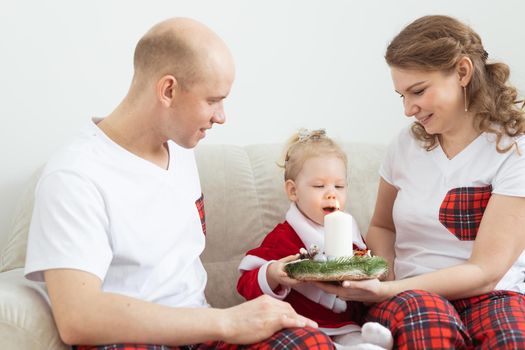 Baby child with hearing aid and cochlear implant having fun with parents in christmas room. Deaf and health