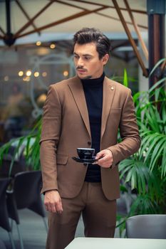 a man in a business suit is drinking tea