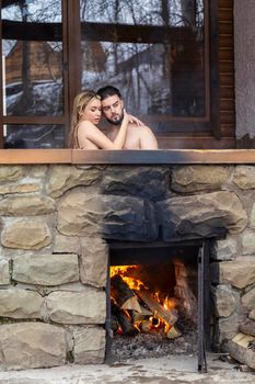 the couple sits in a vat in which the water is heated with the help of firewood