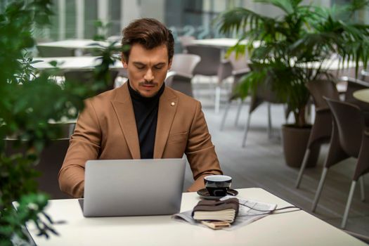 businessman sitting at the table and looking at the computer