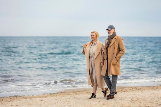 aged couple walking along the seashore