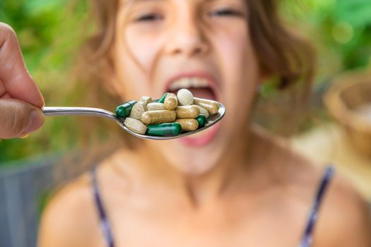 A spoonful of supplements and vitamins for a child. Selective focus. Kid.