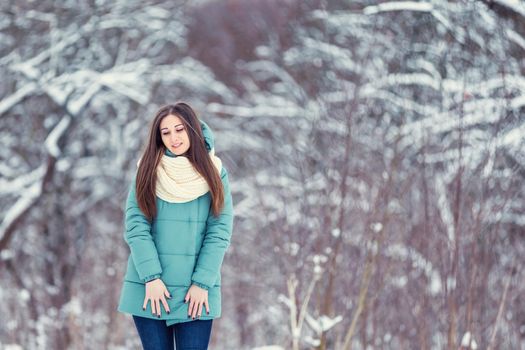 girl in a jacket on the background of snowy trees