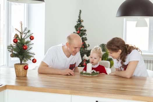 Baby child with hearing aid and cochlear implant having fun with parents in christmas room. Deaf and health