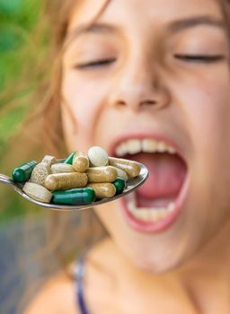 A spoonful of supplements and vitamins for a child. Selective focus. Kid.