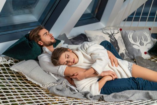 beautiful young couple lies embracing on a stretched net