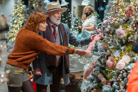 couple aged chooses New Year's decor in the store