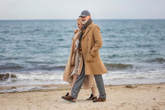 aged couple walking along the seashore