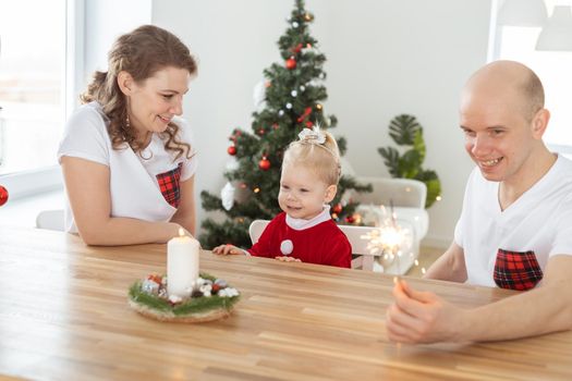 Baby child with hearing aid and cochlear implant having fun with parents in christmas room. Deaf and health