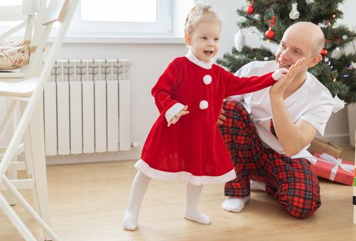 Toddler child with cochlear implant decorating christmas tree deafness and innovating medical technologies for hearing aid