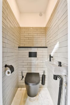 Interior of narrow restroom with sink and wall hung toilet with white walls and checkered floor