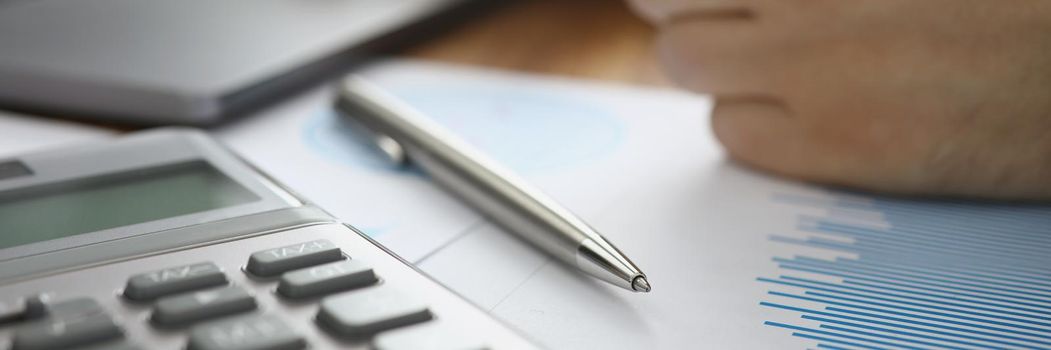 Close-up of person typing on laptop and calculating numbers in office. Businessman using computer to compose report. Business, statistics, success concept