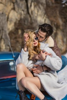 beautiful couple on a retro car in winter