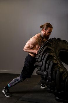 Fitness training man tire flipping wheel fit lifestyle muscular caucasian, for dedication body from effort from strength workout, practicing up. Active energy lifting, sporty