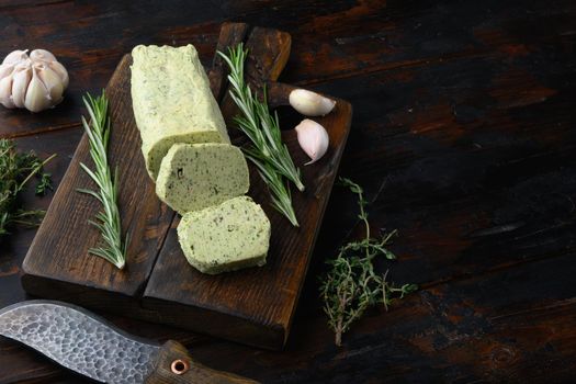 Homemade Organic Herb Butter with Rosemary Thyme and garlic set, on old dark wooden table background, with copy space for text