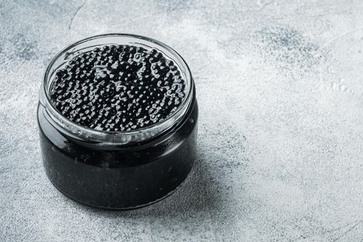 Black sturgeon caviar jar, on gray background with copy space for text