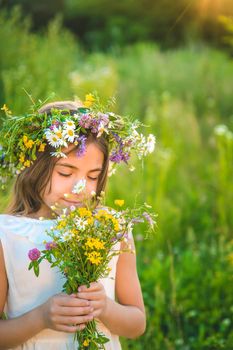 Child girl with wildflowers in summer. Selective focus. Nature.
