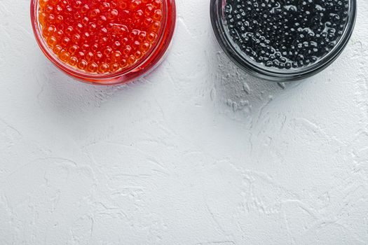 Red and black caviar in glass bowl, on white background, top view flat lay with copy space for text