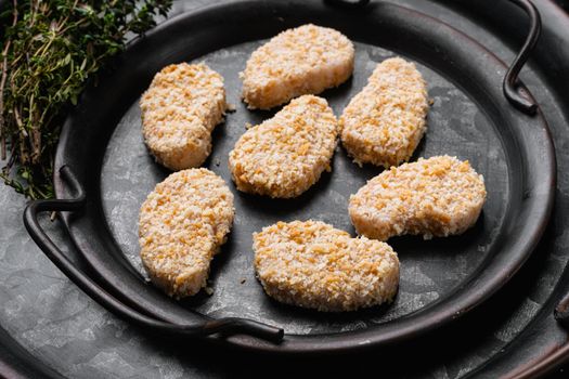 Homemade Raw Breaded Chicken Nuggets, on black dark stone table background