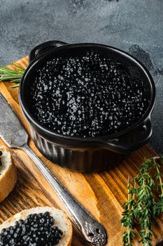 Sandwiches with black caviar and butter, on gray background