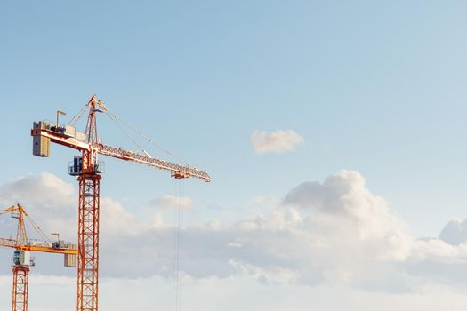 building cranes at the construction site on blue sky background