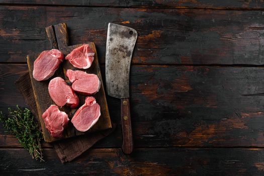 Raw pork medallion steaks, on old dark wooden table background, top view flat lay, with copy space for text