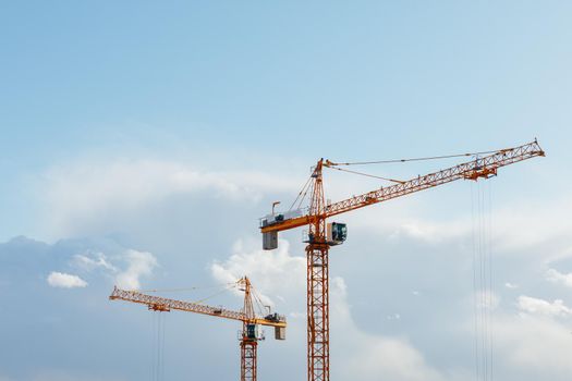 building cranes at the construction site on blue sky background