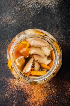 Wild mushrooms Boletus edulis and cap boletus in a jar set, on old dark rustic background, top view flat lay