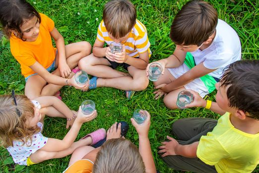 Children drink water outside together. Selective focus. Kids.