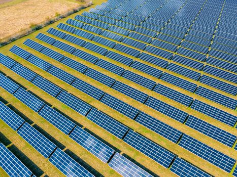 Aerial view of a solar park with many photovoltaic modules for Energiewende from a drone perspective in a rural area