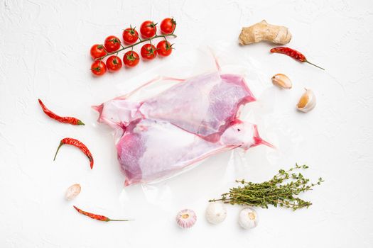 Raw turkey thigh vacuum pack set, top view flat lay, on white stone table background