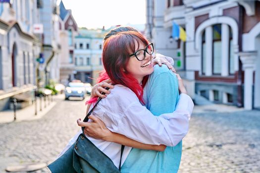 Meeting, hugging teenage male and female friends on the city street. Fashionable having fun teenagers guy and girl together. Friendship, communication, holidays, lifestyle, youth, urban style