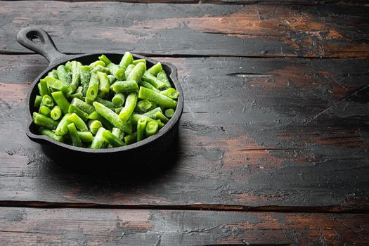 Frozen organic green beans. Healthy food concept set, in frying cast iron pan, on old dark wooden table background, with copy space for text