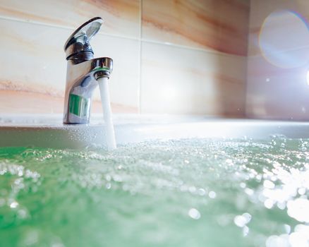 single handle faucet pouring hot water in a bath tub