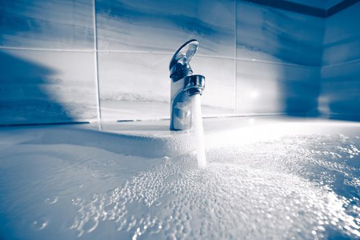 single handle faucet pouring hot water in a bath tub