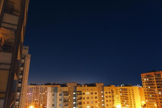 apartment buildings courtyard with view to the night sky and stars on blue background with copy-space