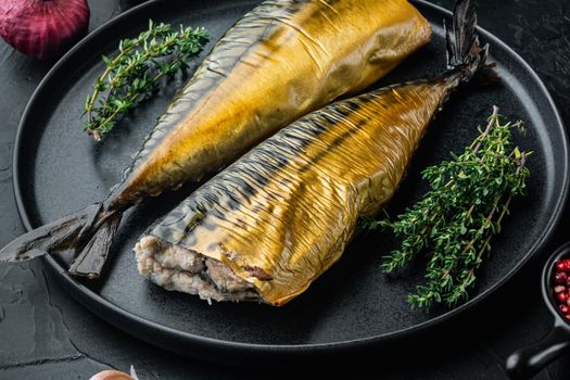 Appetizing smoked fish mackerel, on black background