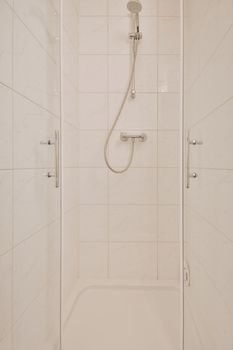 Simple clean shower cabinet with silver colored appliances