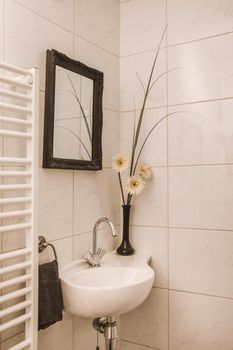 White ceramic sink with flowers in a vase