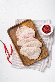Raw schnitzel chicken meat, on white stone table background, top view flat lay