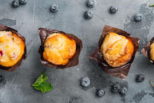 Homemade muffin with fresh blueberries, on gray background, top view flat lay