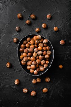 Hazelnut nut health organic brown filbert set, on black dark stone table background, top view flat lay