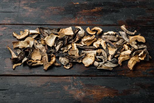 Dried wild mushrooms set, on old dark wooden table background, top view flat lay , with space for text copyspace