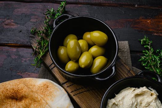 Lebanese bread, pita bread and olives, on old dark wooden table background, with copy space for text