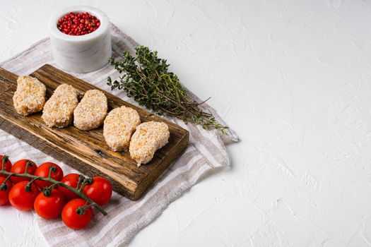 Chicken nuggets uncooked, on white stone table background, with copy space for text