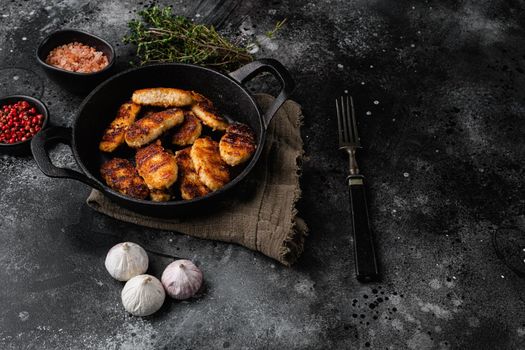 Fried crispy chicken nuggets set, on black dark stone table background, with copy space for text