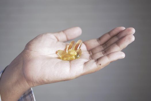 fish oil supplement on hand close up .